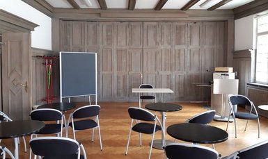 Foto vom Historischen Saal der vhs Erlangen, leere Stühle, ein Podium